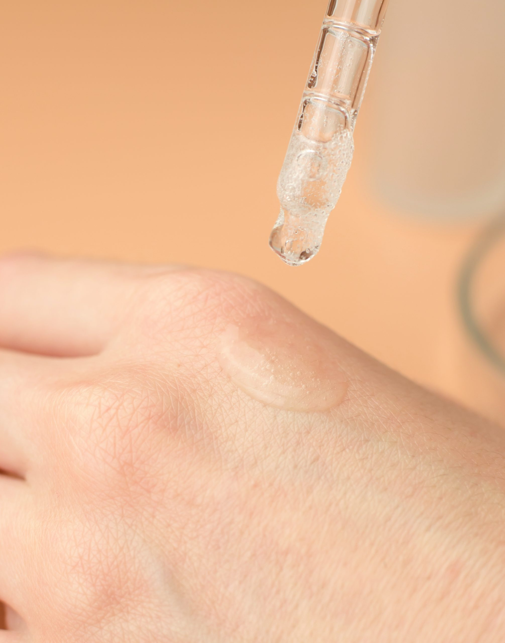 Transparent gel on a female hand. A woman applies a moisturizing gel with a pipette on her wrist.